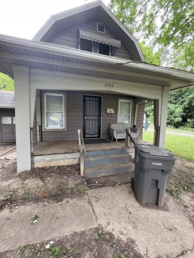 view of front of home featuring covered porch and a gambrel roof