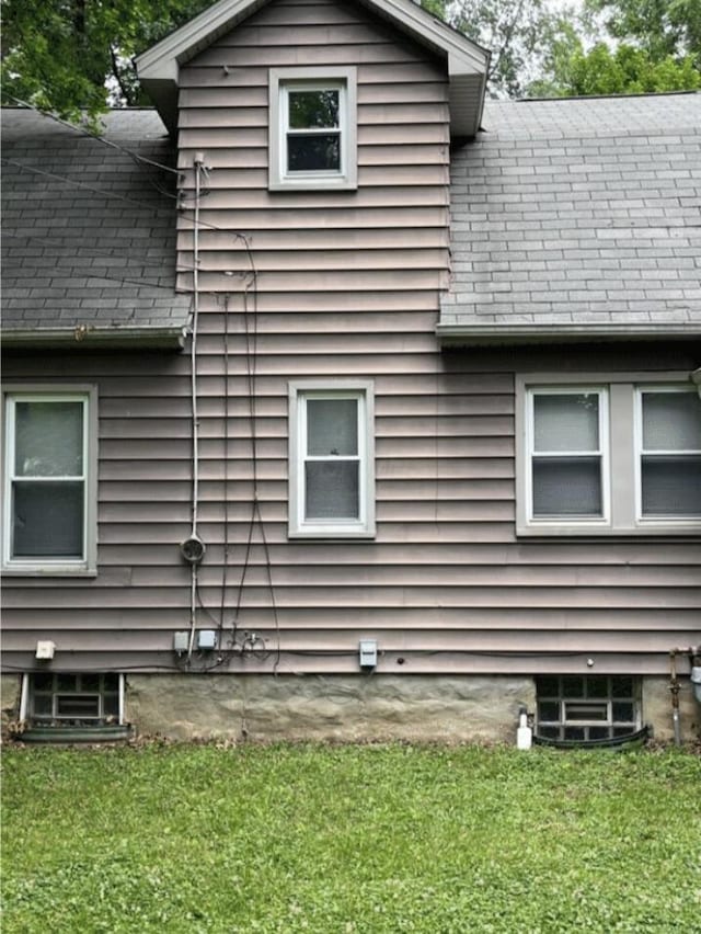 view of property exterior with a shingled roof