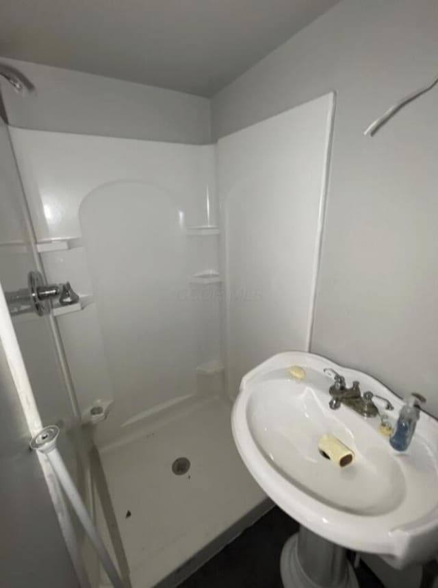 full bath featuring a sink and a shower stall