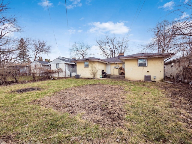 back of property featuring a yard, fence, cooling unit, and stucco siding