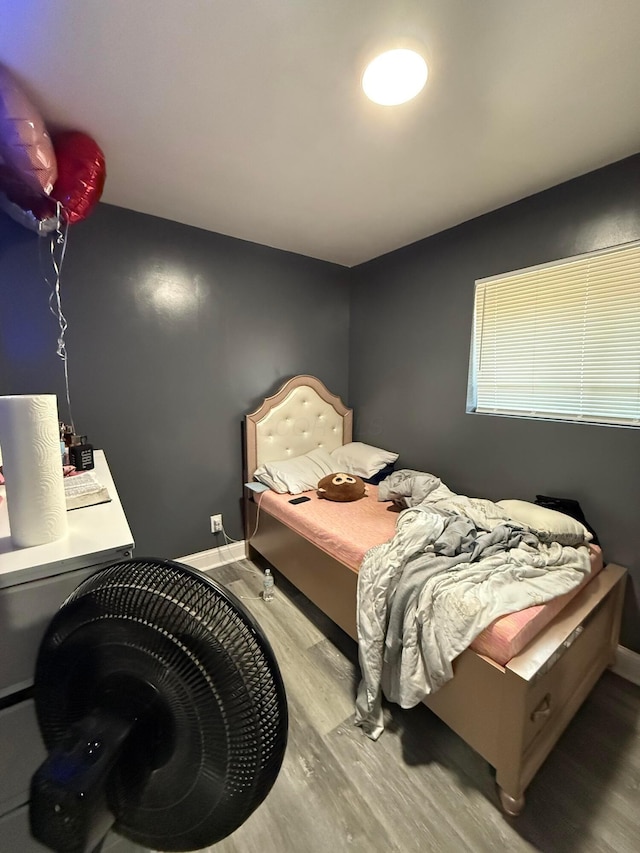 bedroom with baseboards and wood finished floors