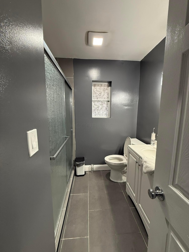 bathroom featuring baseboards, toilet, tile patterned flooring, vanity, and a shower stall