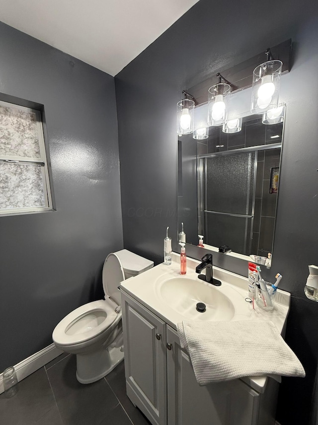 full bath featuring toilet, vanity, baseboards, a shower stall, and tile patterned floors