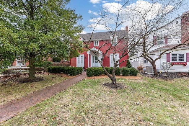 colonial house featuring a front lawn