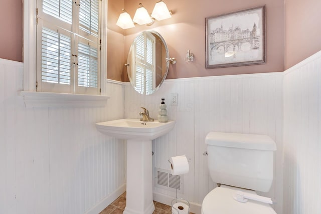 bathroom featuring toilet and wainscoting