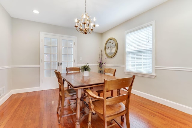 dining room featuring an inviting chandelier, light wood-style flooring, baseboards, and french doors