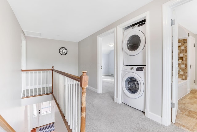 clothes washing area with stacked washer and dryer, carpet floors, laundry area, visible vents, and baseboards