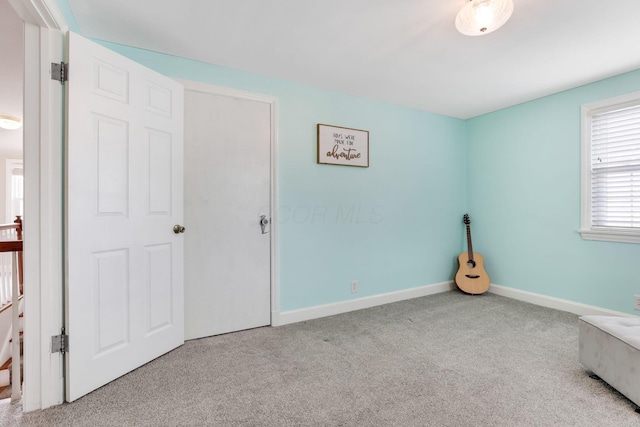 unfurnished bedroom featuring carpet floors and baseboards