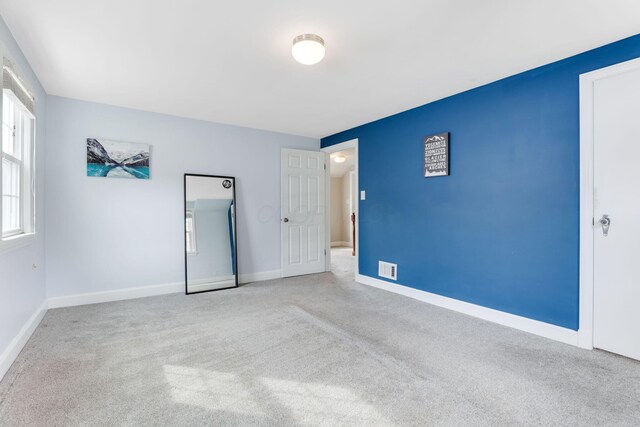 unfurnished bedroom featuring carpet floors and baseboards