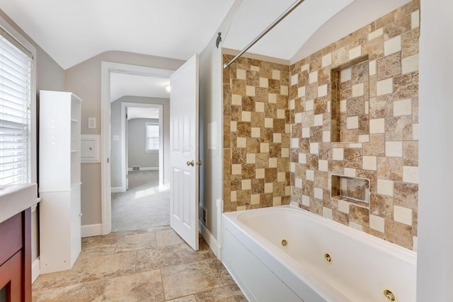 full bathroom with lofted ceiling, baseboards, a tub with jets, and walk in shower