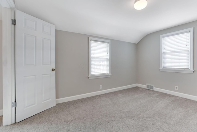 additional living space featuring lofted ceiling, carpet, visible vents, and baseboards