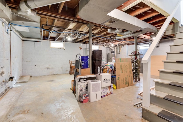 below grade area featuring stairs, visible vents, and electric water heater