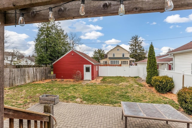 view of yard with an outbuilding, a fenced backyard, and a patio