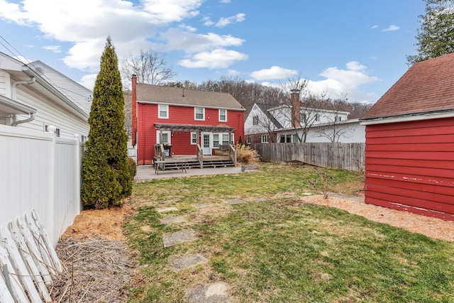 back of property with a fenced backyard, a lawn, a wooden deck, a pergola, and a chimney