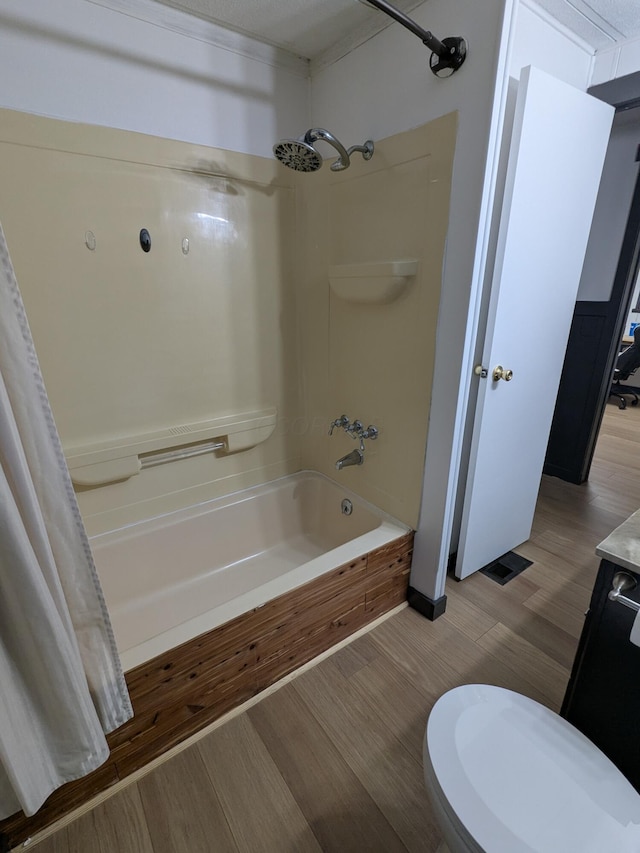 bathroom featuring shower / bathtub combination with curtain, toilet, and wood finished floors