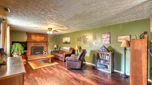 living area featuring visible vents, a textured ceiling, wood finished floors, and a ceiling fan