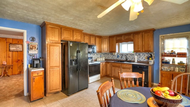 kitchen featuring black appliances, a sink, backsplash, a textured ceiling, and brown cabinetry