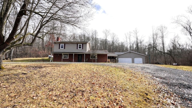 traditional home featuring an outbuilding, an attached garage, and a chimney