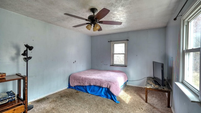 bedroom featuring baseboards, carpet, ceiling fan, and a textured ceiling