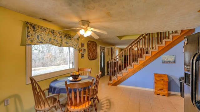 dining room featuring stairway, baseboards, a textured ceiling, and visible vents