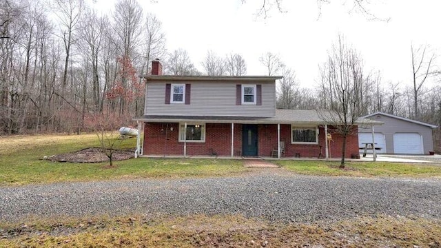 traditional home with a front yard, a garage, brick siding, and a chimney