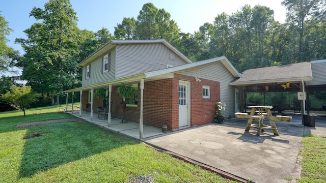 225 Homestead Dr, New Concord, OH 43762 - view of side of property with a lawn, a patio area, and brick siding