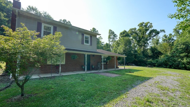 225 Homestead Dr, New Concord, OH 43762 - rear view of property with a lawn, a patio area, a chimney, and brick siding
