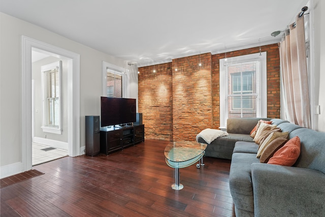 living room featuring a wealth of natural light, visible vents, baseboards, and wood finished floors