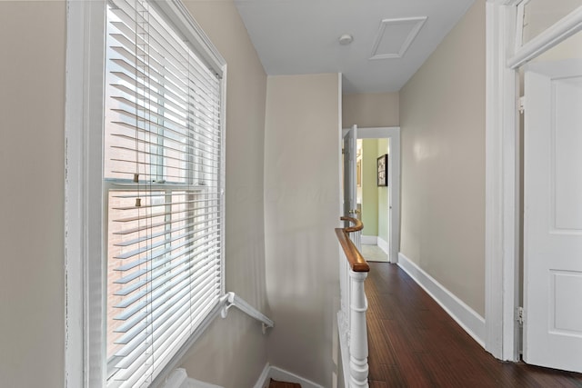 hall with attic access, baseboards, and dark wood-type flooring