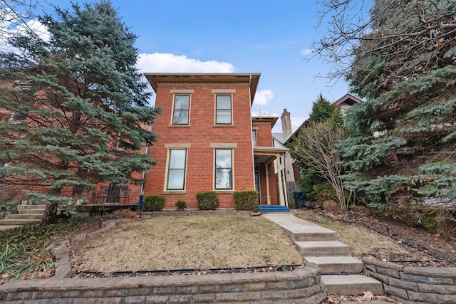 view of front of house featuring a front lawn and brick siding