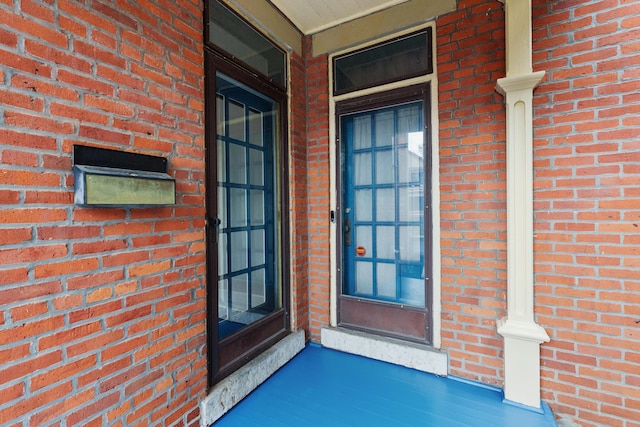 doorway to property with brick siding