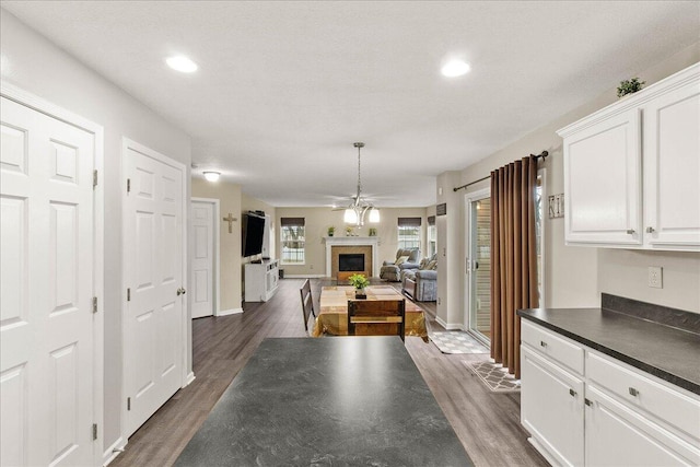 dining space featuring baseboards, a fireplace, dark wood finished floors, and recessed lighting