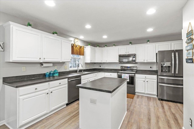 kitchen with stainless steel appliances, light wood-style flooring, a sink, and white cabinetry