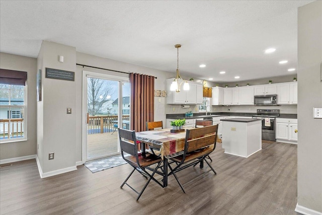 dining space featuring recessed lighting, dark wood finished floors, a textured ceiling, and baseboards