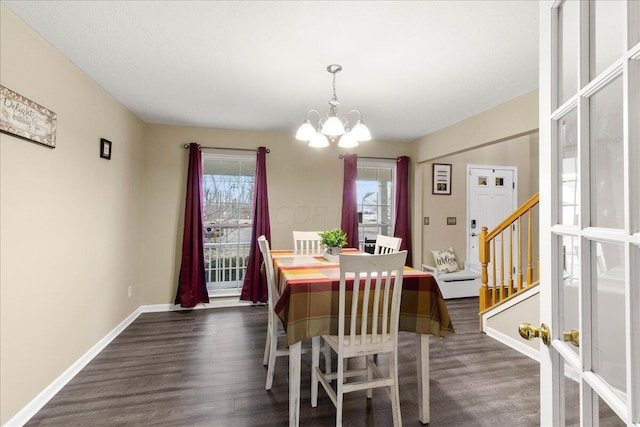 dining room featuring a notable chandelier, dark wood finished floors, and baseboards