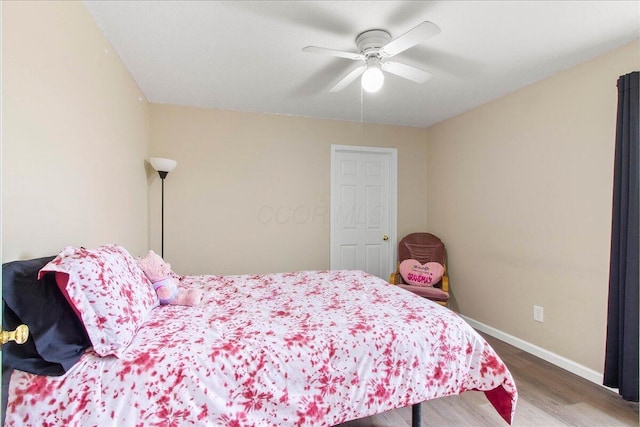 bedroom with wood finished floors, a ceiling fan, and baseboards