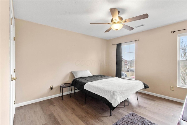 bedroom featuring multiple windows, wood finished floors, and visible vents