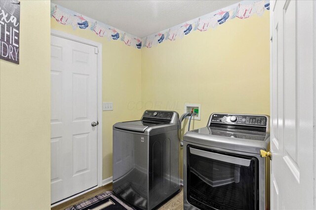 laundry room featuring laundry area, washer and clothes dryer, and wood finished floors