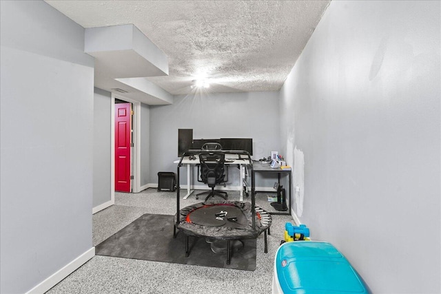 workout area with a textured ceiling and baseboards