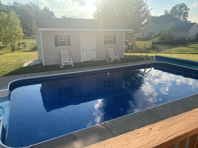 view of pool featuring a fenced in pool, an outbuilding, and a lawn