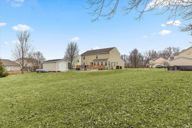 rear view of house with a yard, an outdoor structure, fence, and a shed