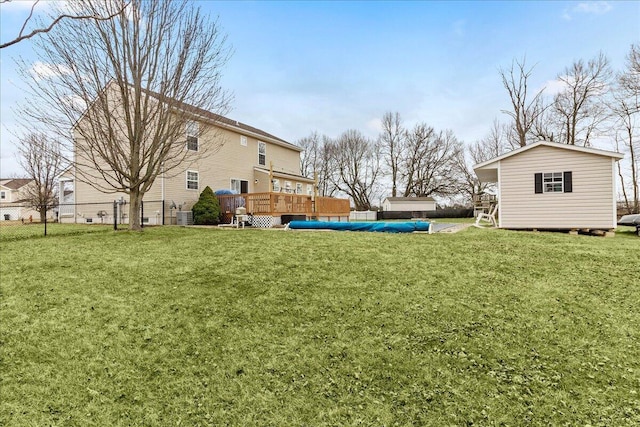 view of yard with a deck, an outdoor structure, and fence