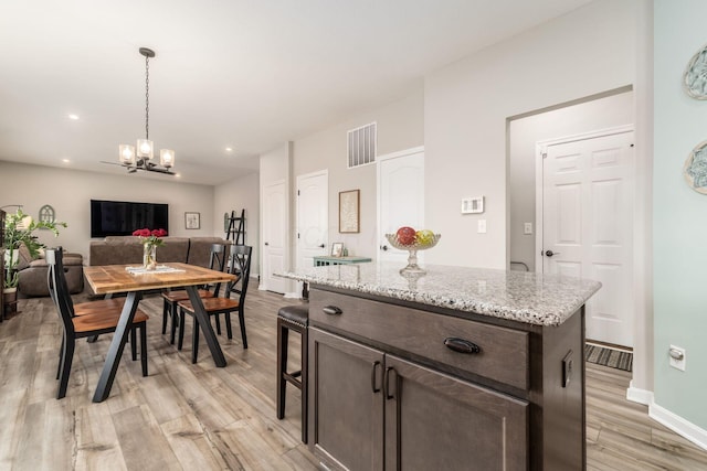 kitchen featuring a notable chandelier, light wood finished floors, visible vents, hanging light fixtures, and dark brown cabinets