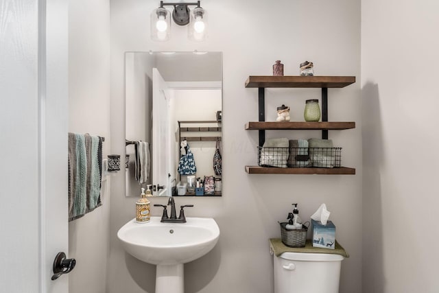 half bath featuring toilet and a sink