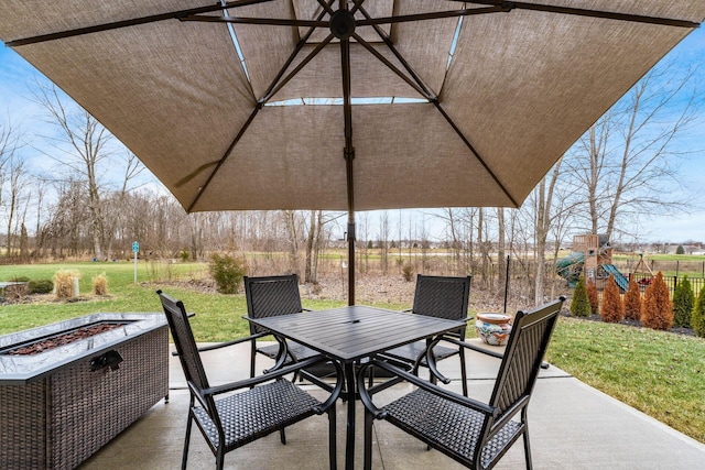 view of patio featuring outdoor dining area, a playground, and a fire pit