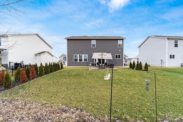 rear view of property with a patio, fence, and a lawn