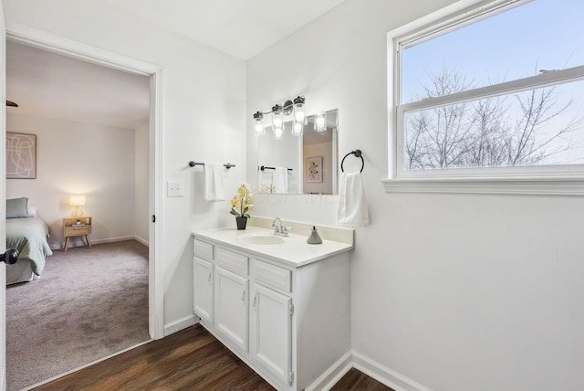 bathroom featuring vanity, baseboards, and wood finished floors