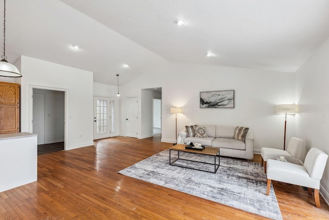 living area with hardwood / wood-style flooring, baseboards, and vaulted ceiling