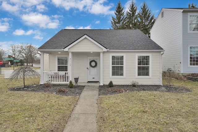 bungalow-style house featuring a porch, a shingled roof, and a front lawn