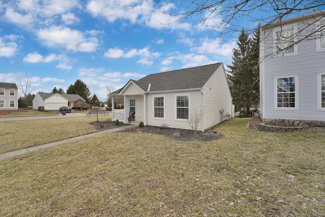 view of front of house featuring a shingled roof and a front yard